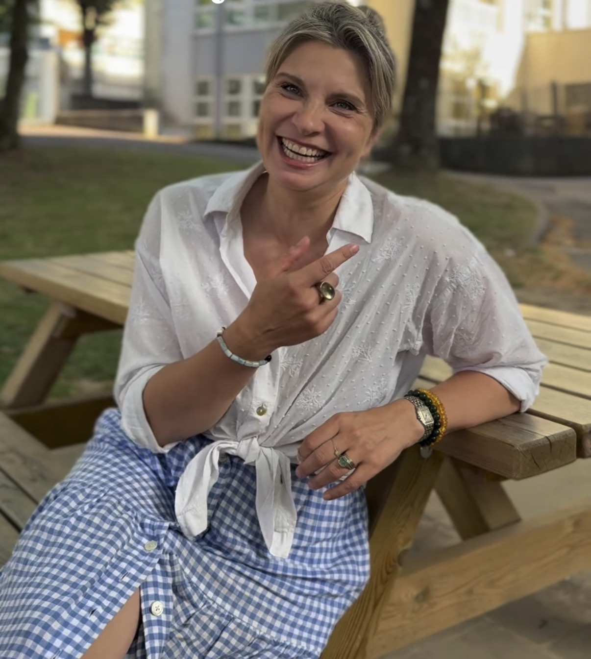 One of the podcast hosts smiling outdoors at a picnic table